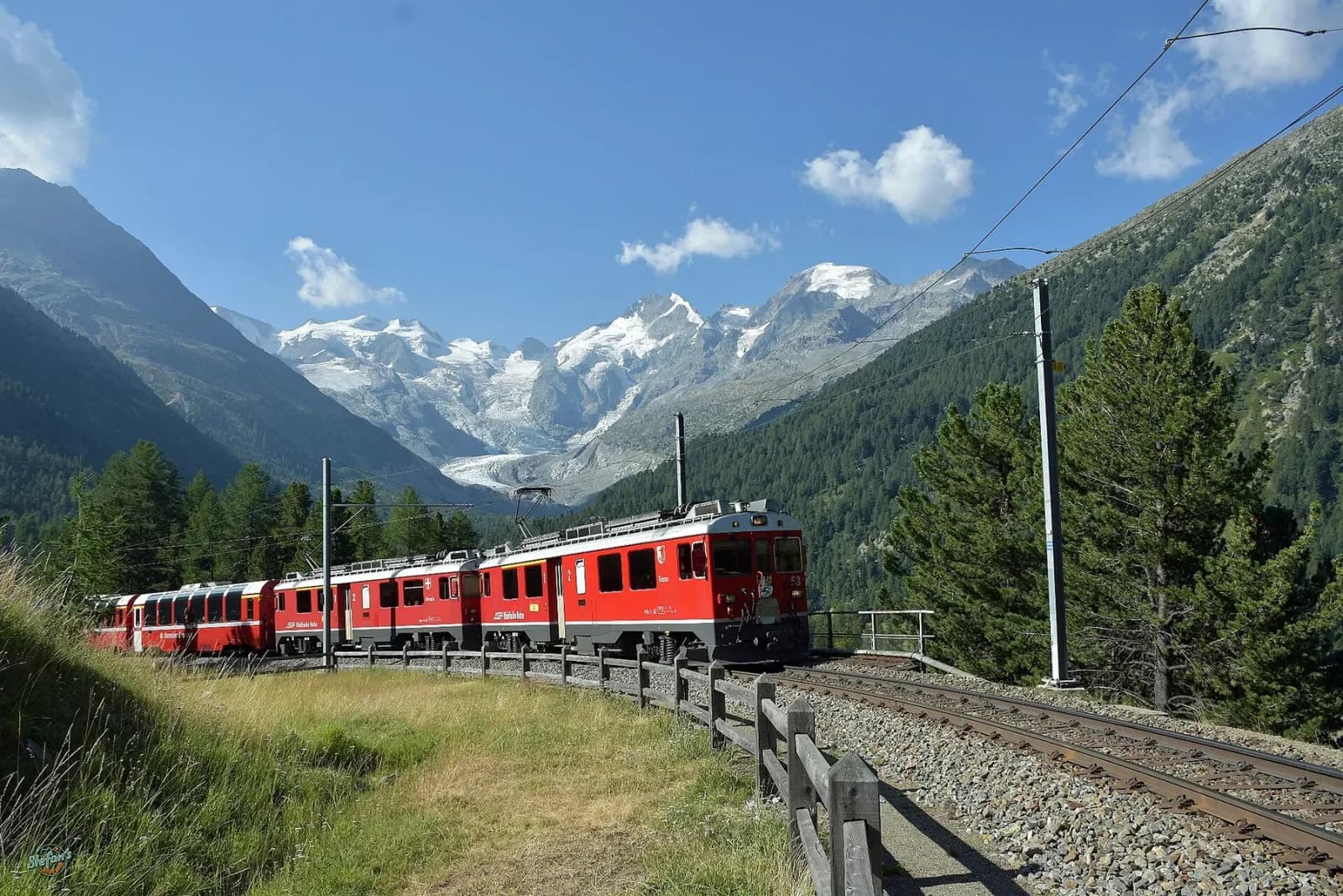 A red Bernina Express curving beneath glacier-covered peaks near Morteratsch